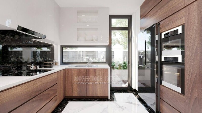 Là một trong những xu hướng trang trí nội thất nổi bật trong những năm tới, thiết kế phòng bếp hiện đại tôn lên vẻ đẹp mộc mạc nhưng không kém phần sang trọng của gỗ điển hình là gỗ óc chó veneer . Loại gỗ rất được ưa chuộng trong các siêu xe bởi vẻ đẹp ấn tượng từ vân, màu gỗ. Như trong ý tưởng bố trí phòng bếp tại biệt thự Vinhomes Imperia, sự hài hòa tôn lên nét đẹp giữa truyền thống và hiện đại, tủ bếp dưới gỗ óc chó veneer và tủ bếp trên acrylic trắng bóng. Tủ bếp gỗ công nghiệp và tủ bếp acrylic